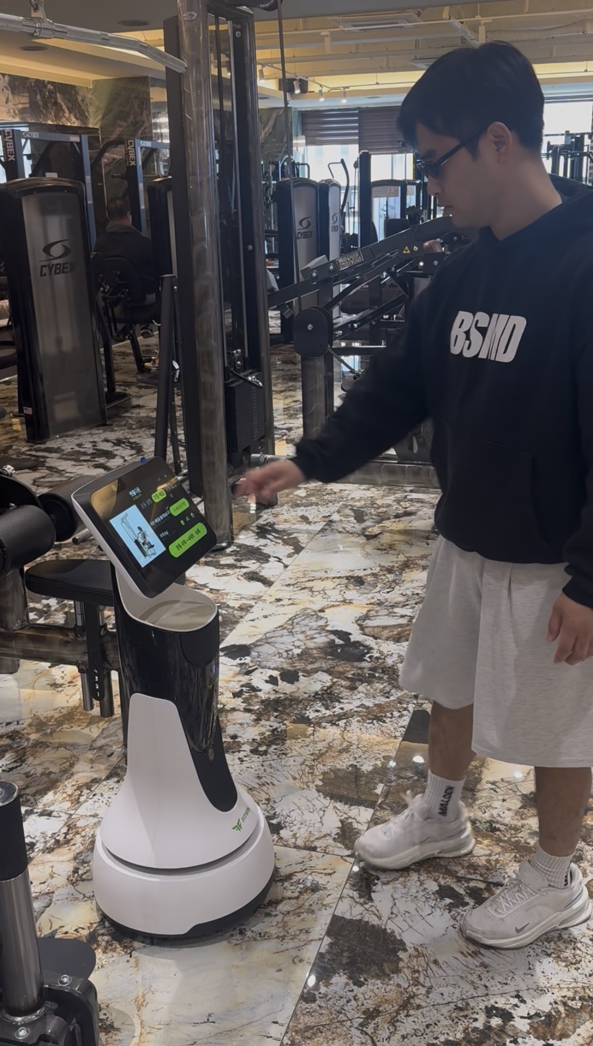 FITWIN Manager robot interacting with a gym member